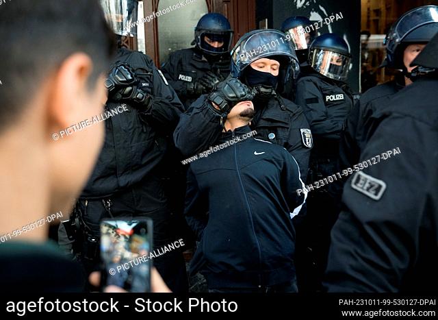11 October 2023, Berlin: Police officers take away a young man in the Neukölln district. Earlier, a pro-Palestinian demonstration in the district was banned -...