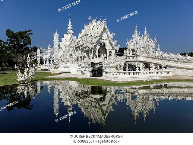 Wat Rong Khun, White Temple, by architect Chalermchai Kositpipat, ubosot reflected in the water, Chiang Rai, Chiang Rai Province, Northern Thailand, Thailand