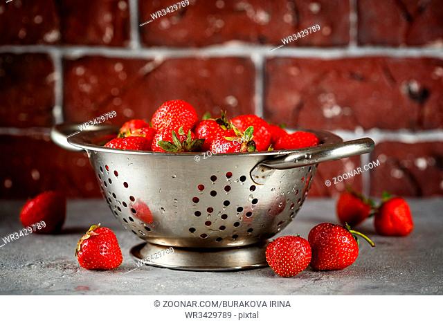 Fresh juicy appetizing strawberries in metal colander