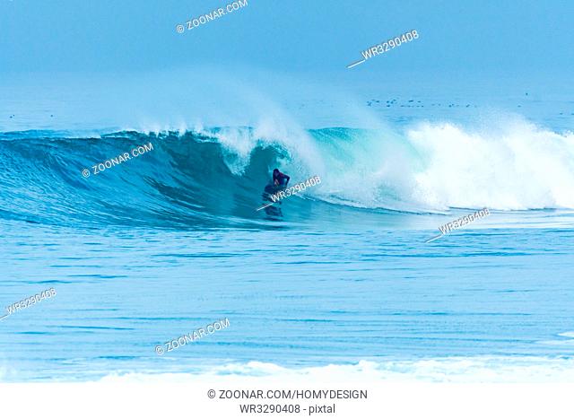 Bodyboarder surfing ocean wave on a sunny day