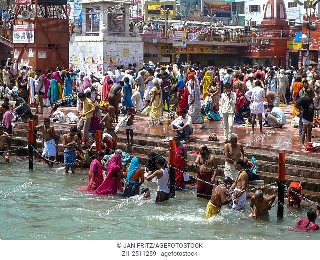 pilgrims taking a holy bath at the ganga river during kumbh mela in haridwar, india