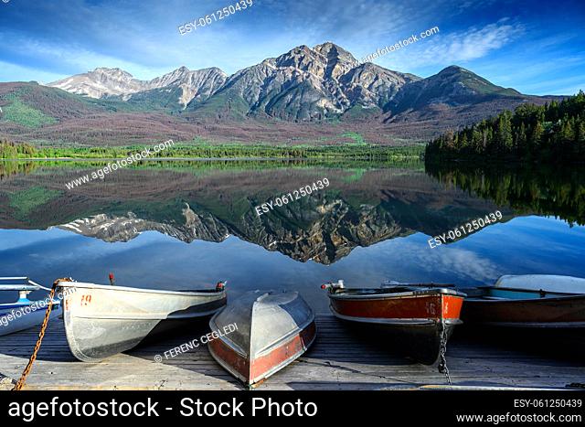 The Patricia Lake with some boat at the lakeshore ready for summer season and there is the beautiful reflecting Pyramid Mountain in the background