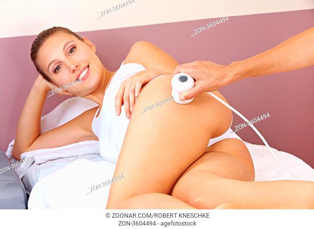 Hautstraffung durch Elektrostimulation bei attraktiver Frau im Fitnesscenter