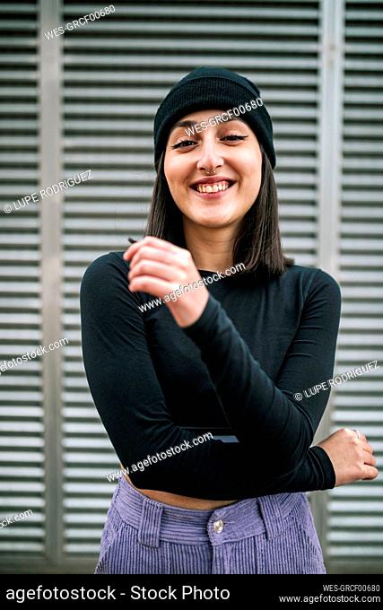 Happy young woman against metallic shutter