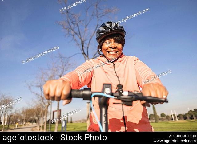 Senior woman holding handlebar of electric push scooter