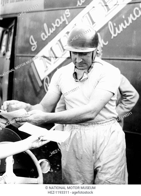 Ken Wharton signing autographs. He started out driving an Austin Seven at Donington Park in the immediate prewar years. Not only did he drive in Formula One