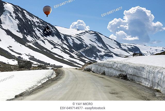 hot air balloon above the snow in summer on the gamle strynefjellsvegen one of the most beautifull auto roads in norway with snow in summer