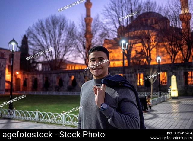 Turkey, Istanbul, Portrait of smiling man in front of Sultan Ahmet mosque