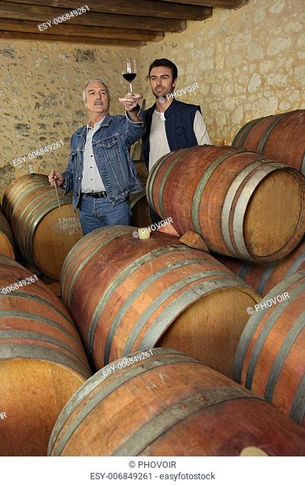 Two men tasting wine in cellar