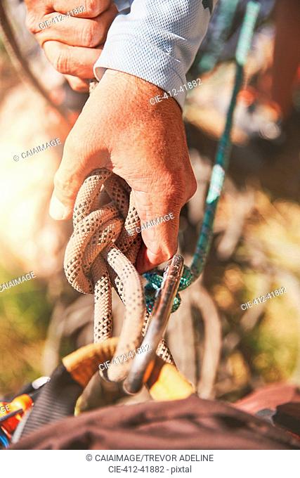 Close up rock climber holding knotted rope