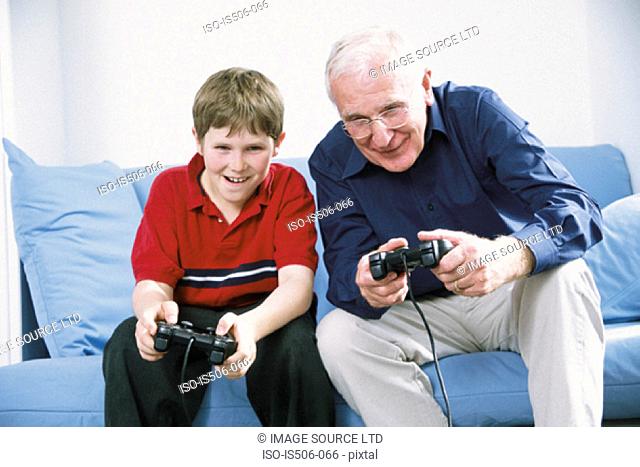 Grandfather and grandson playing with computer game