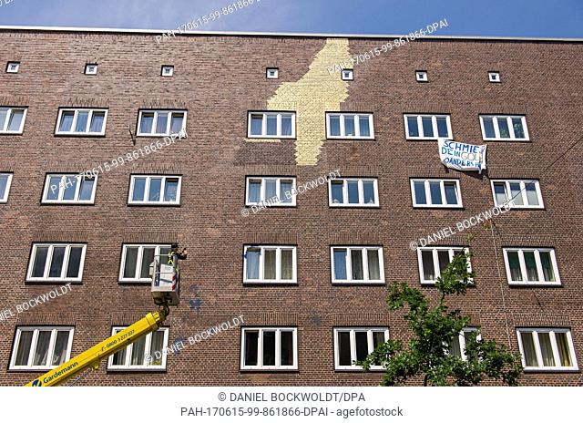 The artist Boran Burchhardt photographs blue colour patches on the house facade in the district Veddel, Hamburg, Germany, 15 June 2017