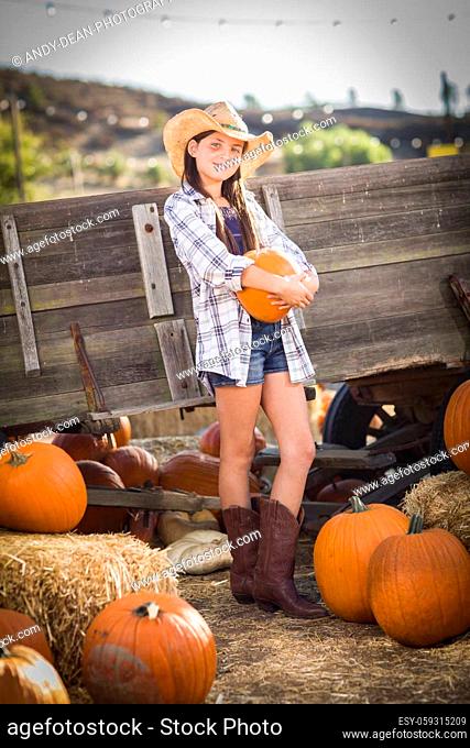 Preteen Girl Wearing Cowboy Hat Portrait at the Pumpkin Patch in a Rustic Setting