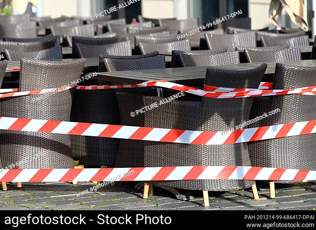 dpatop - 14 December 2020, Saxony, Dresden: A barrier tape surrounds tables and chairs in front of a restaurant on Neumarkt