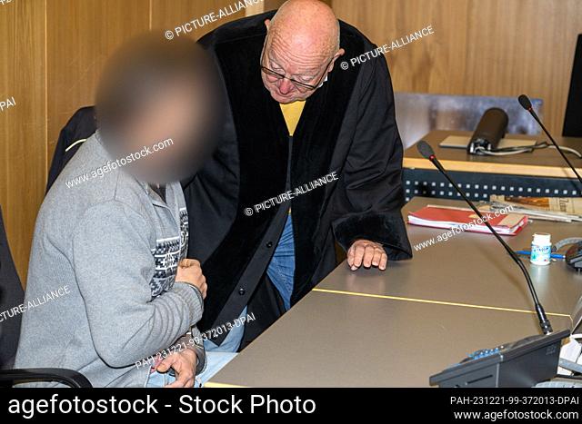 21 December 2023, Baden-Württemberg, Ulm: Defense lawyer Stfan Holoch (r) talks to his client in the district court. The defendant is accused of distributing...