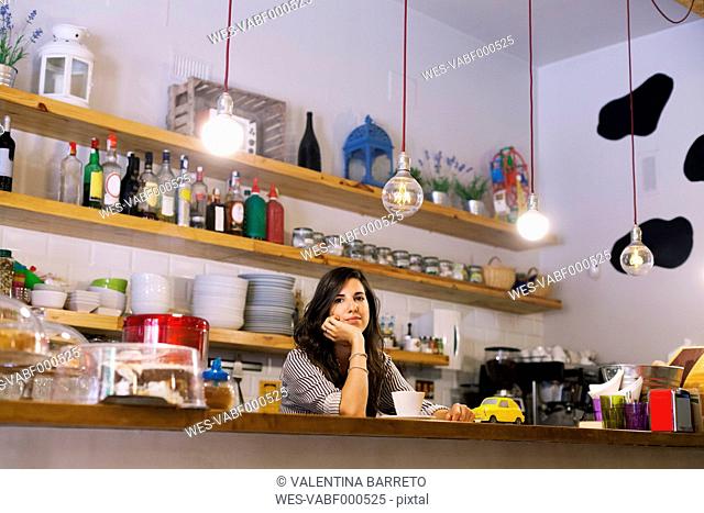 Young woman working in her own little cafe