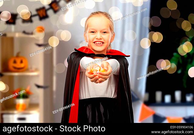 girl in halloween costume of dracula with candies