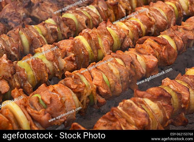 Pieces of meat and onion threaded on metal skewers and grilled over hot coals. Shashlicks. Picnic food