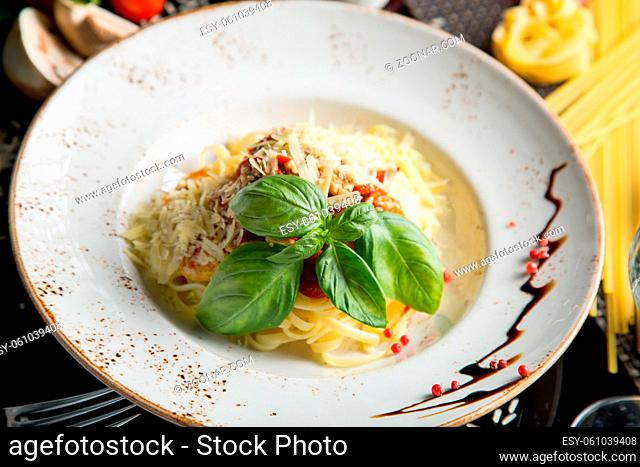 Italian pasta with parmesan cheese and creamy sauce and bacon. Spaghetti in a plate with herbs. Concept - food, delicacies