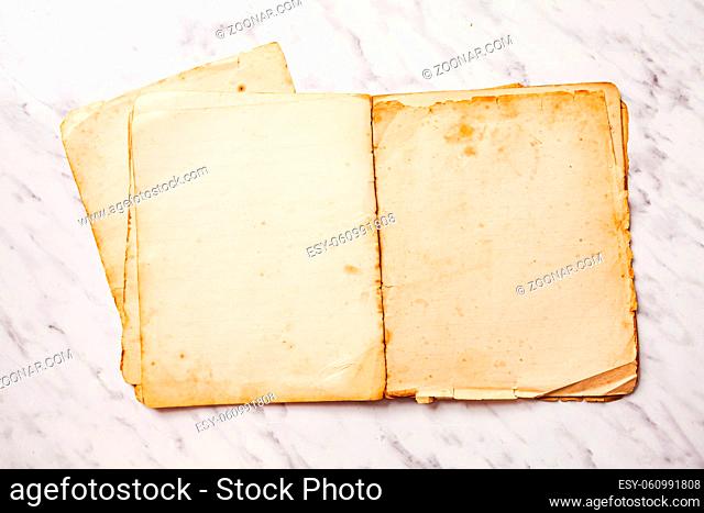 The ancient school notebook with ruined pages on the table top view