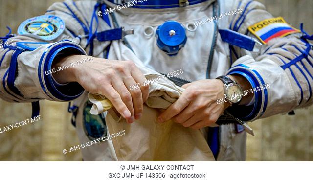 Expedition 49 Russian cosmonaut Sergei Ryzhikov of Roscosmos dons his Russian Sokol suit ahead of the Soyuz qualification exams with fellow Russian cosmonaut...