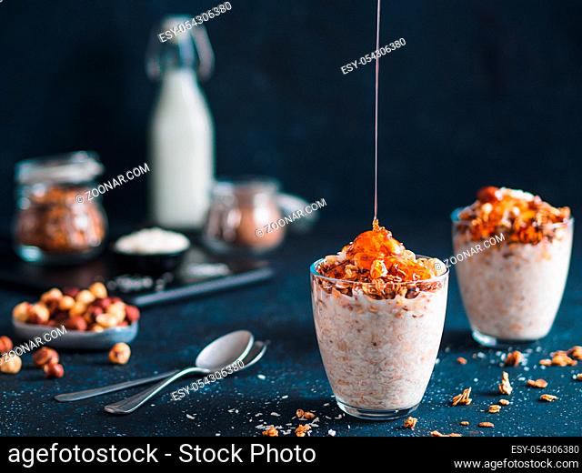 Gingerbread coconut overnight oatmeal served with granola, pecan, honey.Recipe and idea healthy vegan breakfast - plant-based milk overnight oats with chia and...
