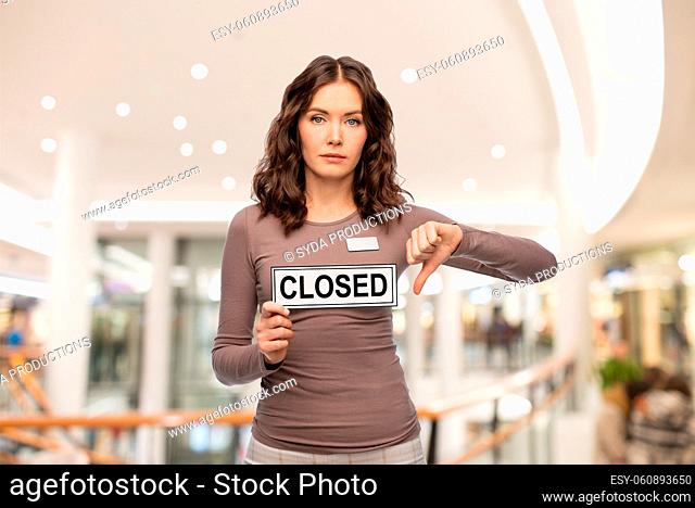 shop assistant with closed sign shows thumbs down