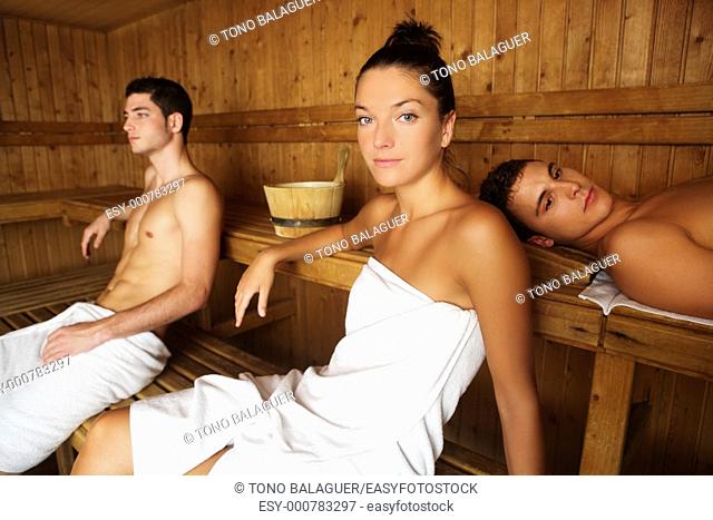 Sauna spa therapy young people group in warm wooden room white towel