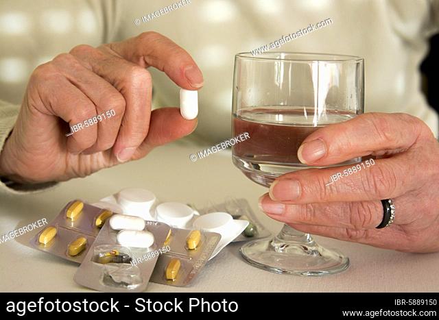 Woman holding medication pill, France, Europe