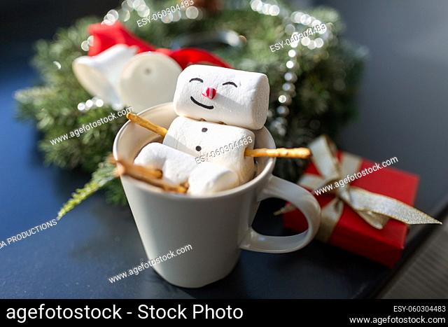 marshmallow snowman in cup of coffee on christmas