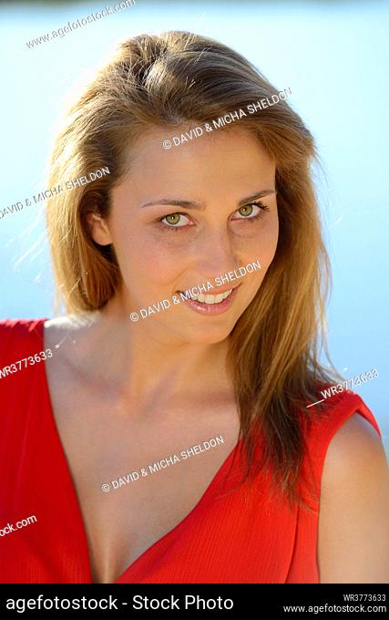 Young woman wearing red dress outdoors, portrait