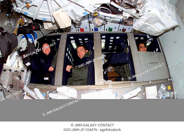 Three STS-107 crewmembers are pictured prior to their sleep shift in bunk beds on the middeck of the Space Shuttle Columbia