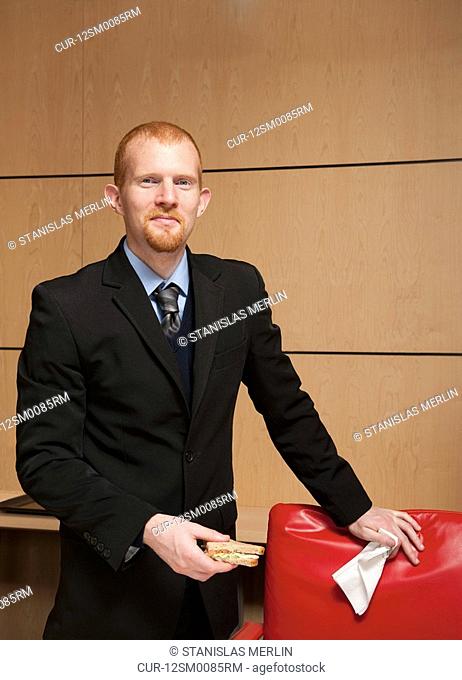 Young businessman with sandwich