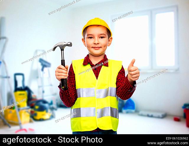 boy in helmet with hammer showing thumbs up