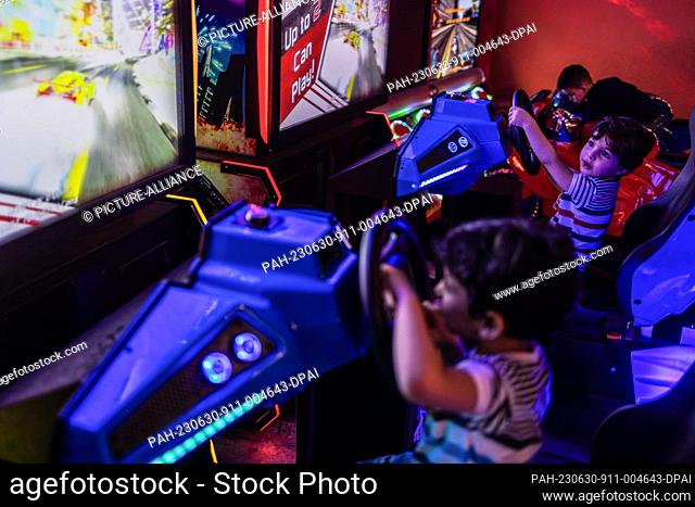 29 June 2023, Syria, Idlib: Syrian children play video games at the City Park during the celebrations of the Eid al-Adha holiday in Idlib