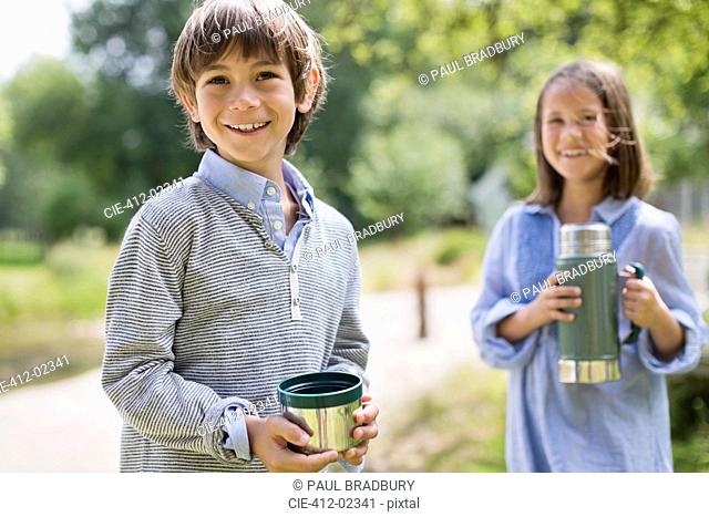 Children drinking from thermos outdoors