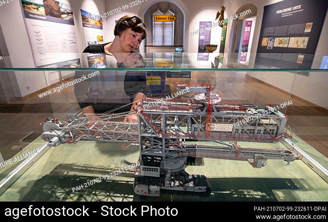 02 July 2021, Saxony, Torgau: Barbara Schneider looks at the model of a bucket-wheel excavator in the exhibition ""Lost Places