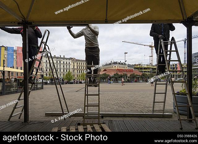 Riga, Latvia, Men installing an awning at an outdoor restaurant