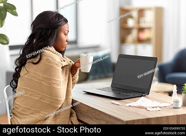 sick woman with tea having video call on laptop