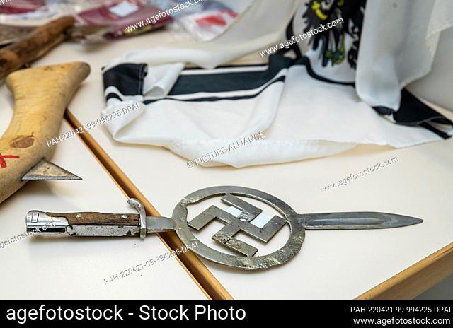 21 April 2022, Baden-Wuerttemberg, Heilbronn: A bayonet with an embedded swastika as well as a Reich flag, which were seized during a police operation in...