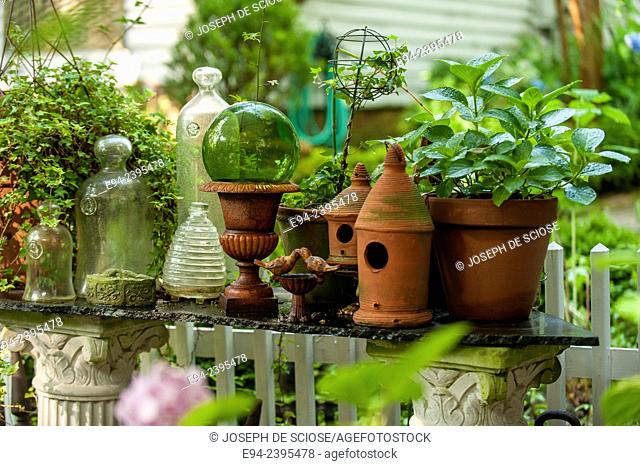 A garden vignette showing terra cotta pots and glass decoration on a table outdoors.Georgia USA