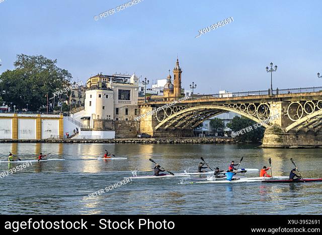 Kayaks on the Guadalquivir river at the Puente de Isabel II bridge, Seville, Andalusia, Spain