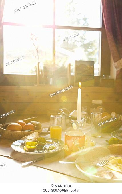Close up of sunlit breakfast table in log cabin