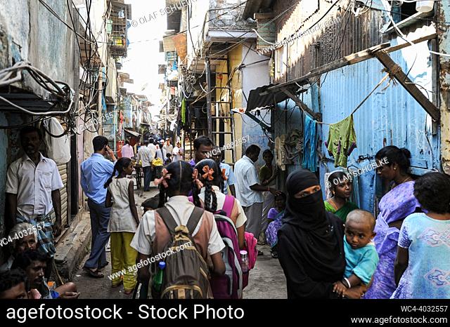 Mumbai, Maharashtra, India, Asia - Everyday scene with people in a narrow back alley in the Dharavi slum of Mumbai. The locality of Dharavi is located in the...