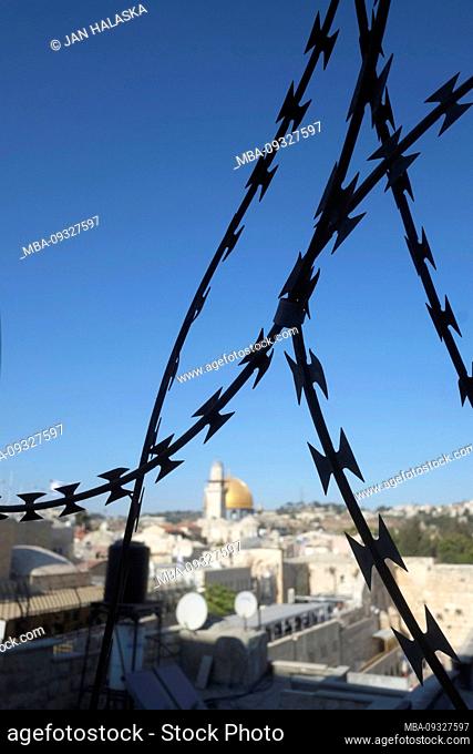 Israel - Jerusalem. Dome of the Rock and Western Wall viewed through a razor wire fence