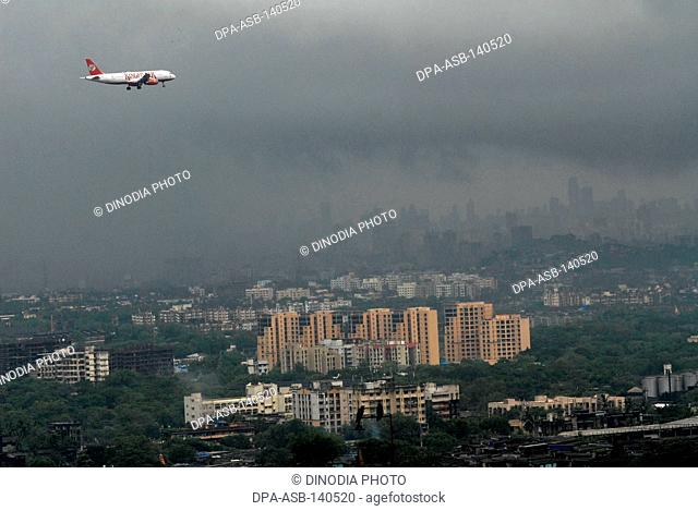 A Kingfisher Airlines commercial plane approaching the airport amidst dense monsoon clouds in Bombay now Mumbai ; Maharashtra ; India