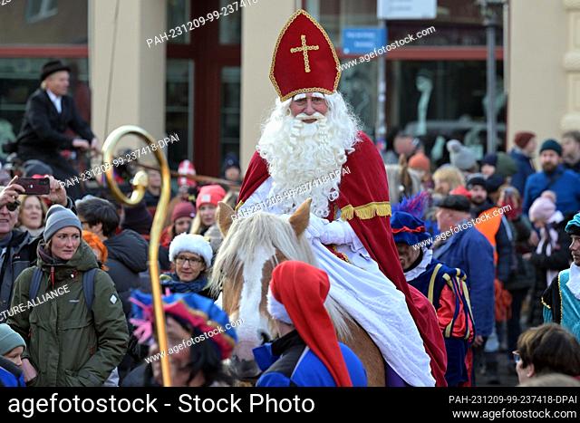 09 December 2023, Brandenburg, Potsdam: The historic Dutch Santa Claus figure Sinterklaas rides into Potsdam's Dutch Quarter to open the local Christmas market