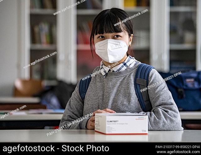 17 March 2021, Berlin: Claudia Dinh, student, sits in the classroom of the Lessing-Gymnasium in Wedding-Berlin and has her Covid-19 quick tests in front of her
