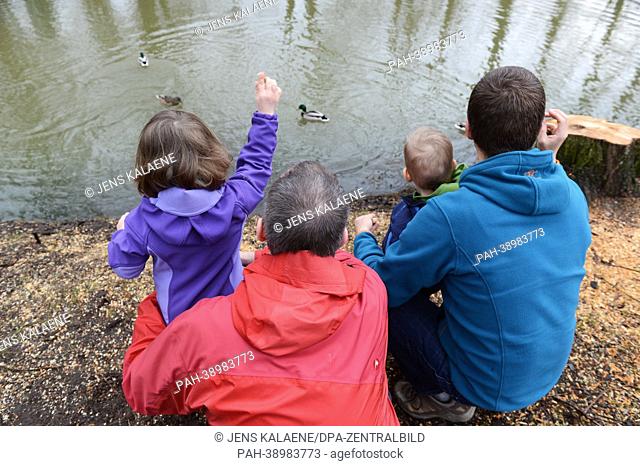 Homosexual couple which lives in a same-sex partnership feeds ducks with two children on a lake in Berlin, Germany, 11 April 2013