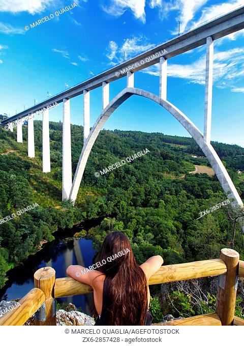 Young girl watching modern bridge for the high speed AVE train at Gundian viewpoint of Ulla River. Vedra Council. A Coruña province near Santiago de Compostela...